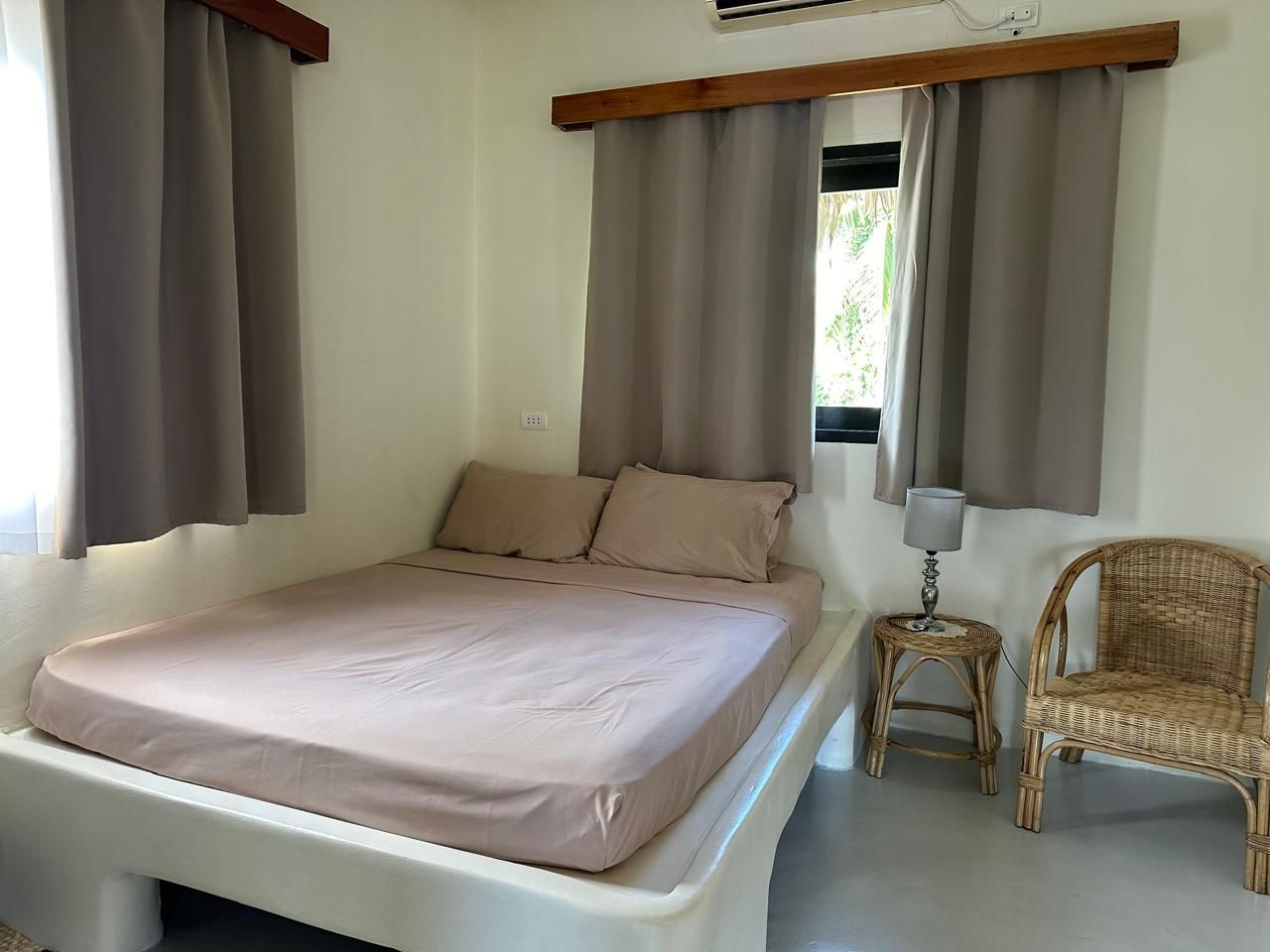 A bedroom with a bed , chair , table and window.