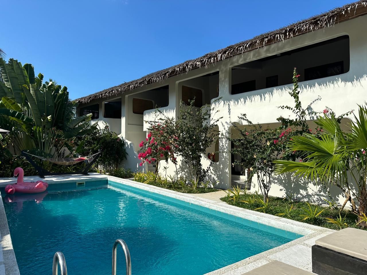 A large swimming pool in front of a white building