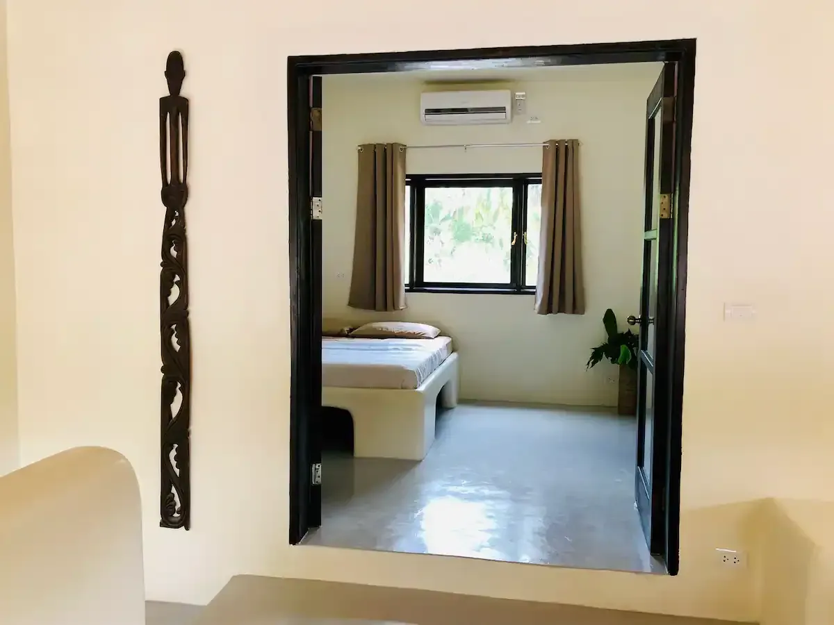 A bedroom with a bed and a window.