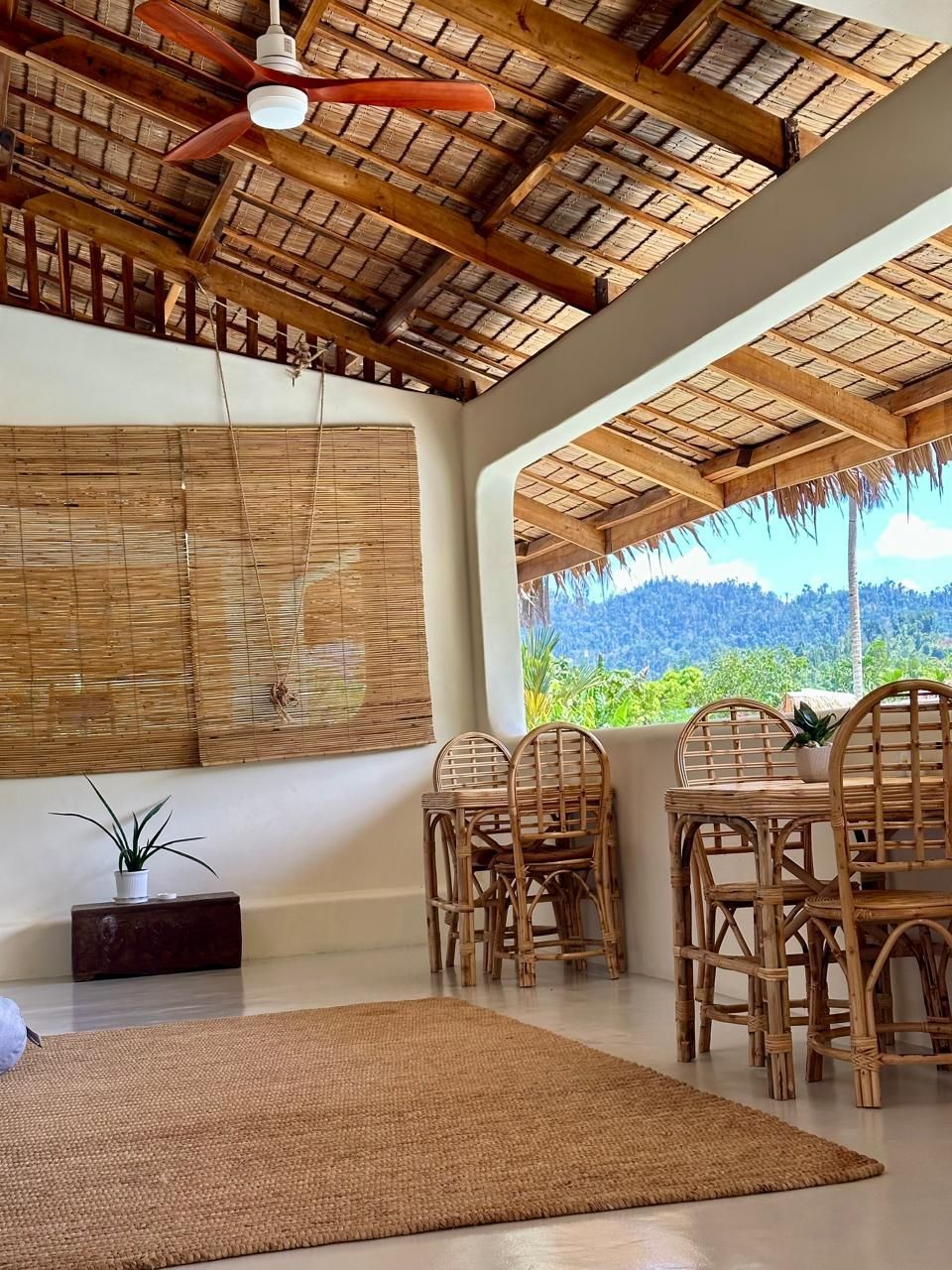 A room with a table and chairs and a ceiling fan