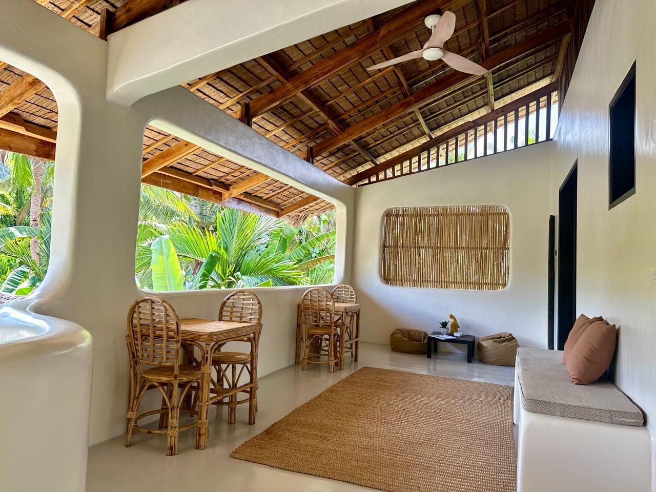 A living room with a table and chairs and a ceiling fan.