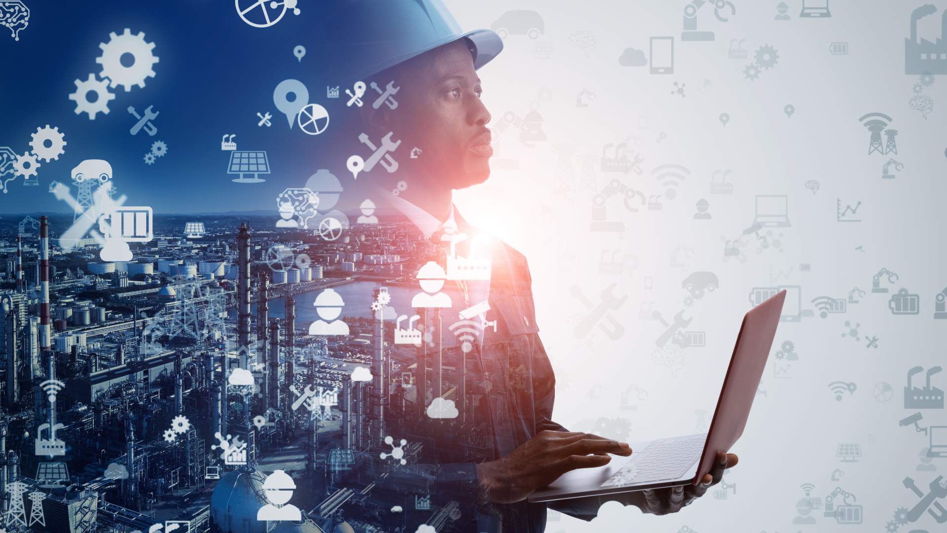 A man wearing a hard hat is holding a laptop computer.