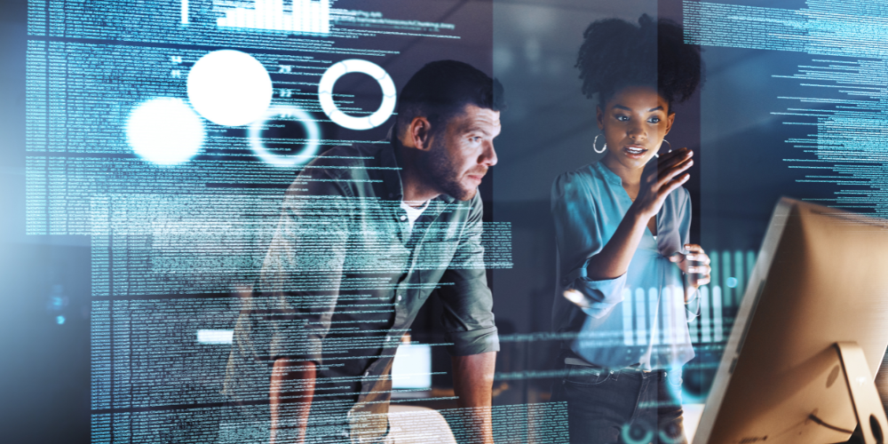 A man and a woman are looking at a computer screen.