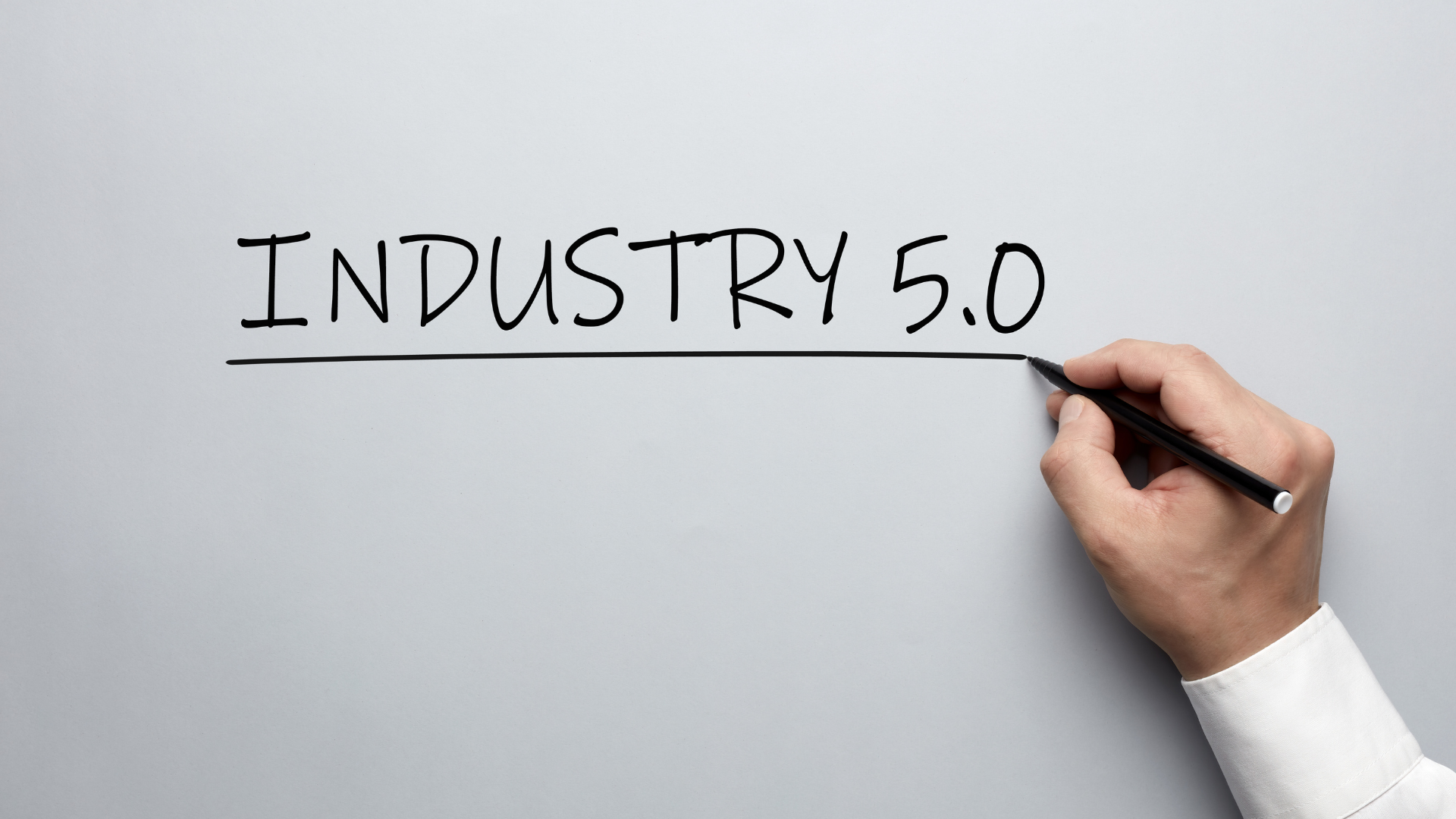 A person is writing the word industry 5.0 on a white board.