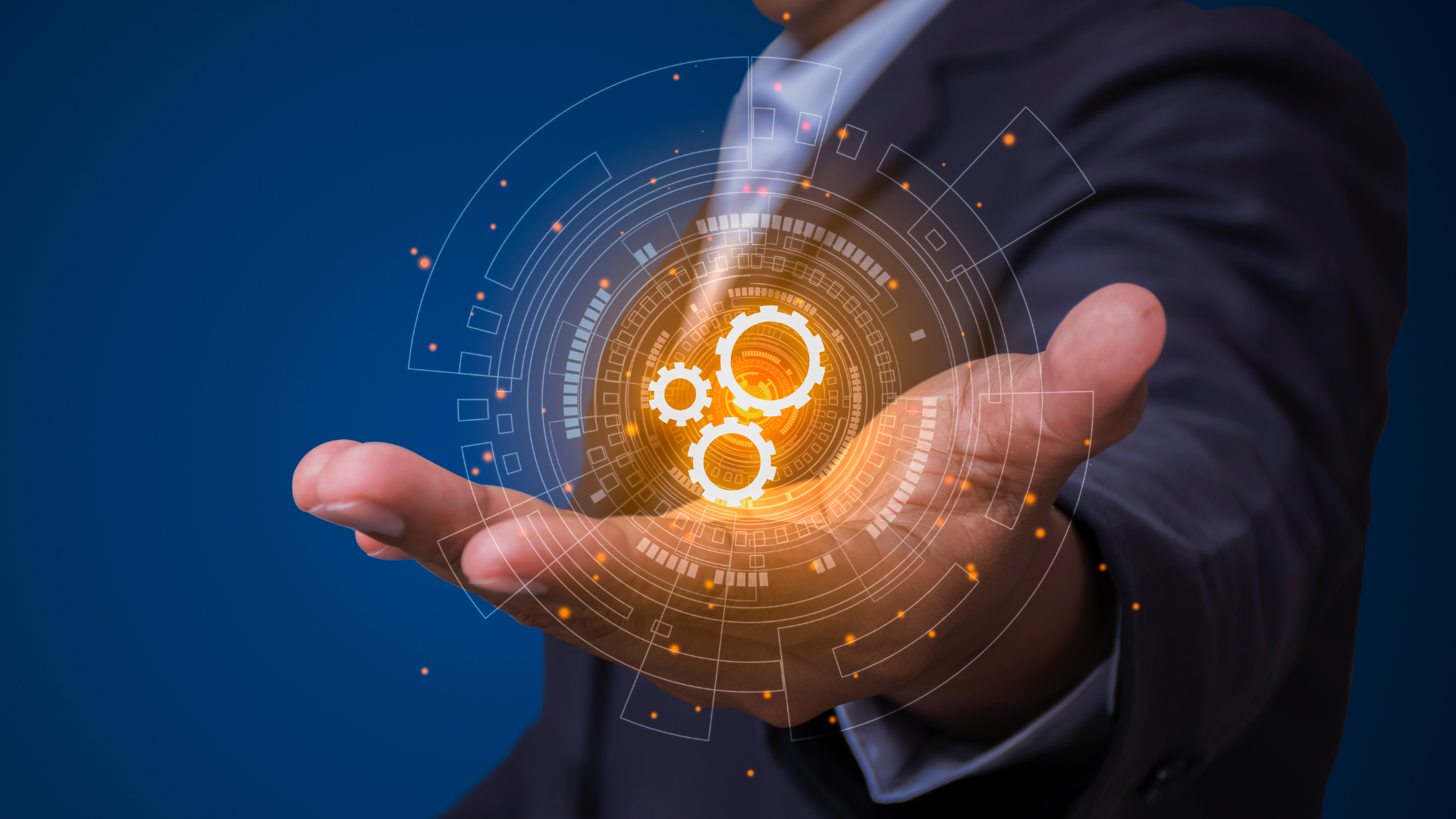 A man in a suit is holding a gear icon in his hand.