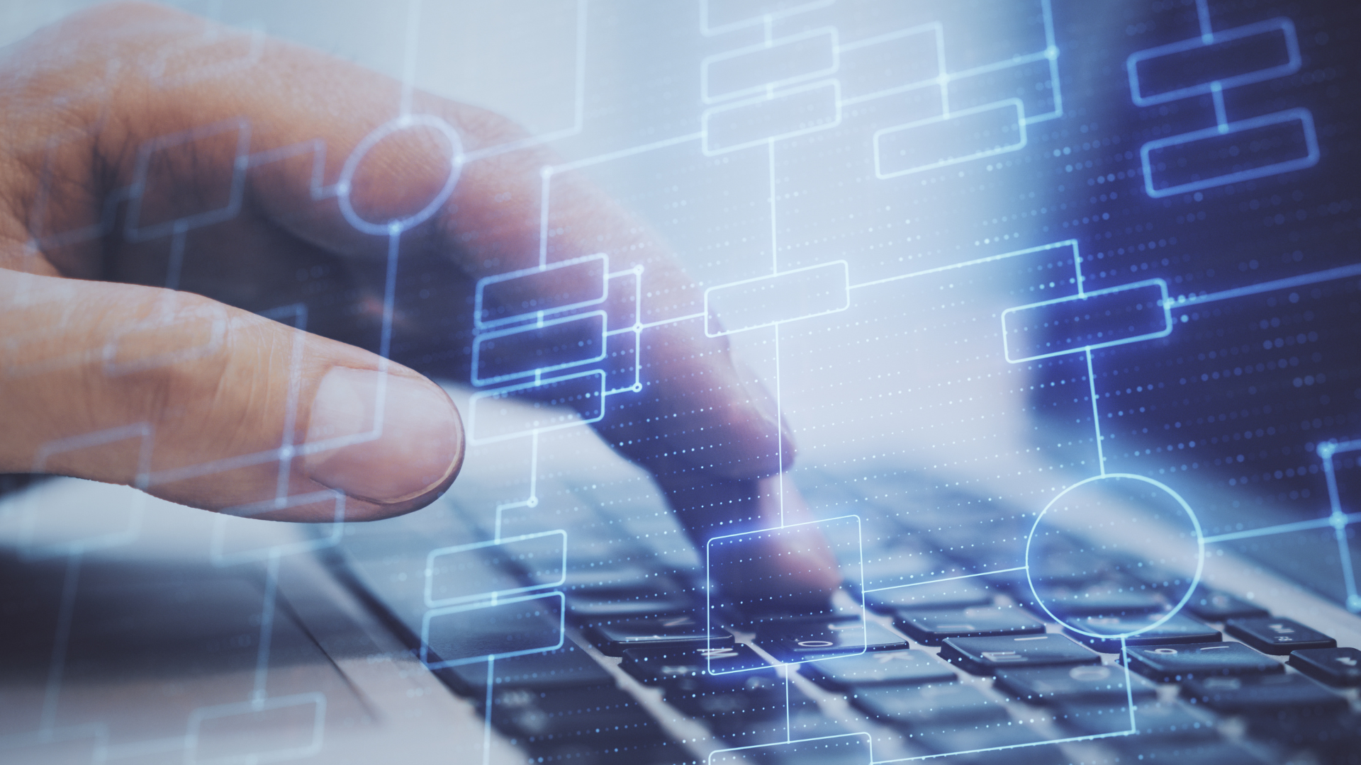 A person is typing on a laptop computer with a diagram in the background.