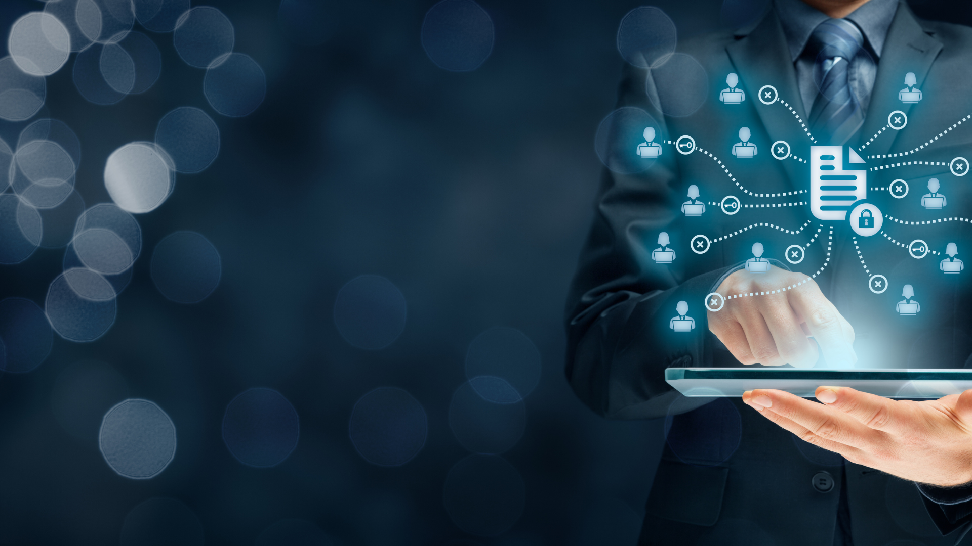A man in a suit and tie is holding a tablet in his hands.