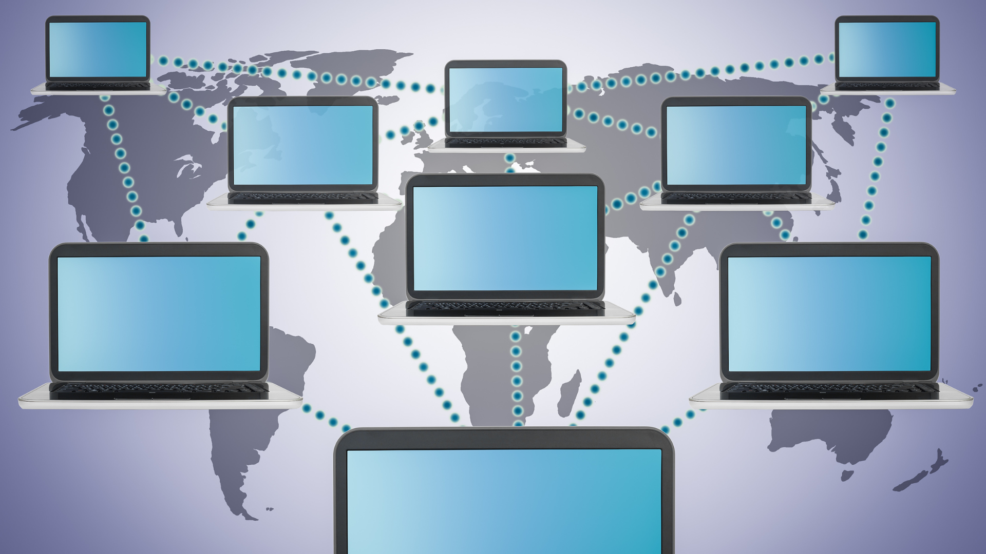 A bunch of laptops are connected to each other in front of a map of the world