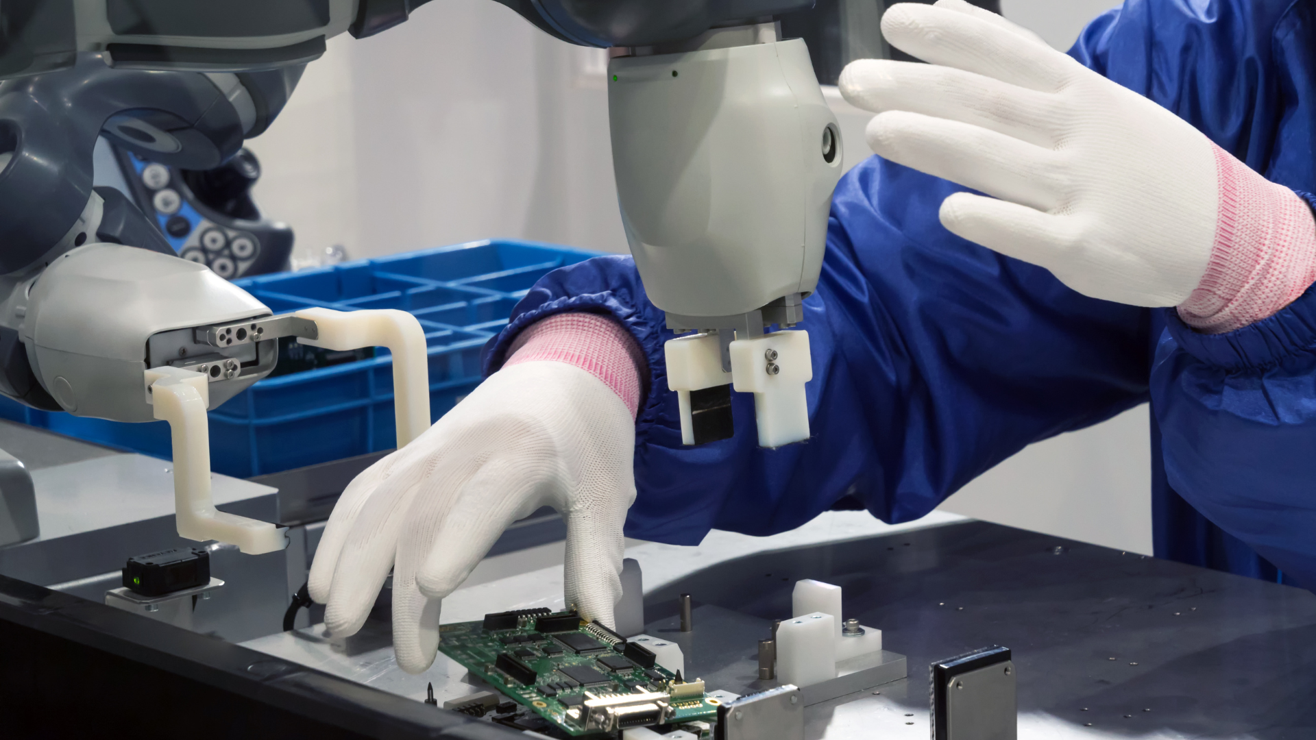 A person is working on a robotic arm in a factory.