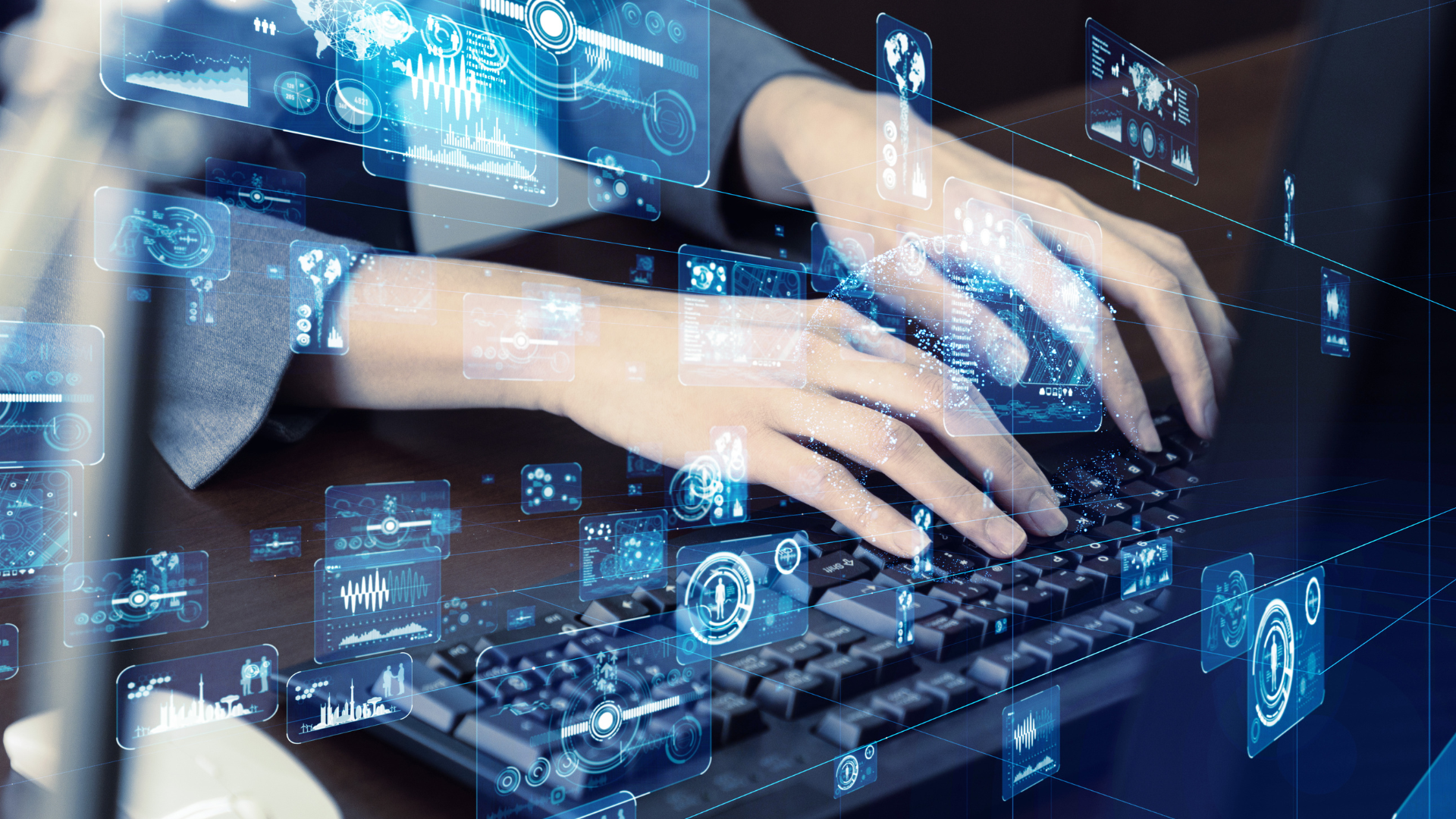 A person is typing on a computer keyboard with a futuristic screen behind them.