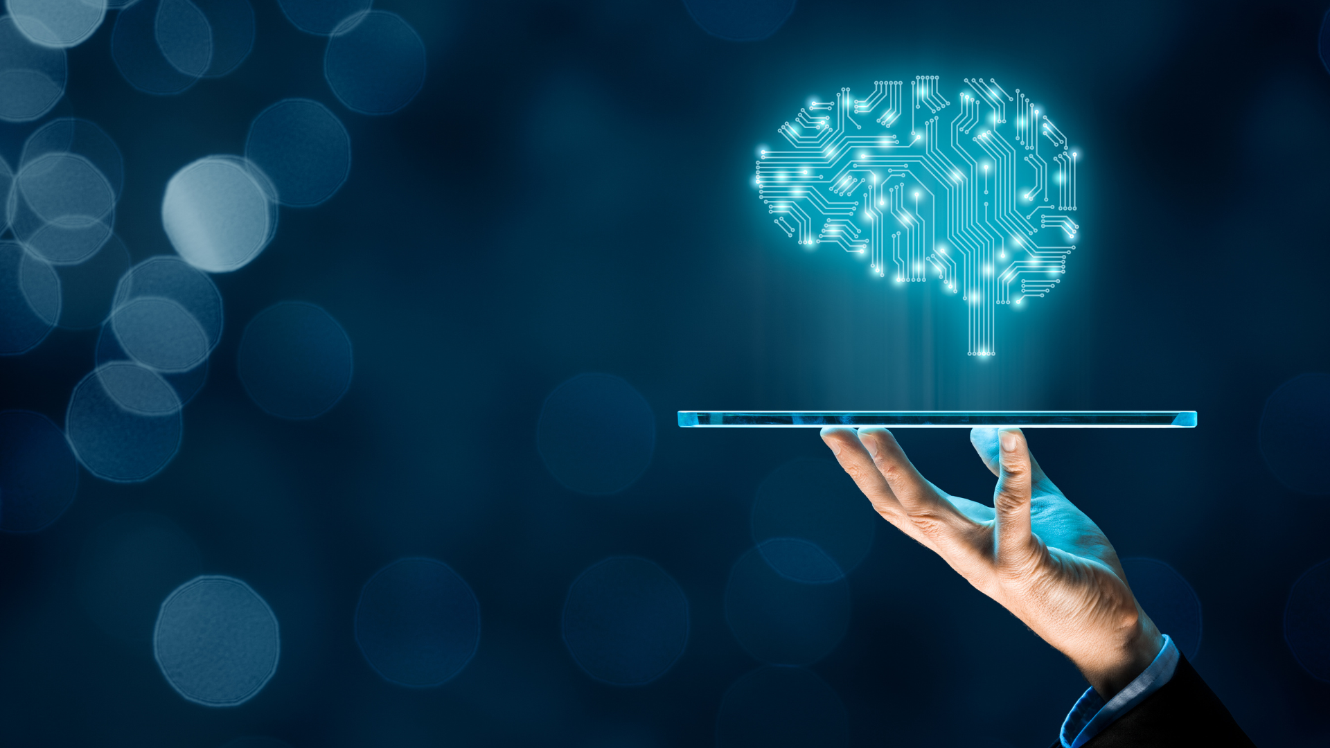 A hand is holding a tablet with a brain coming out of it.