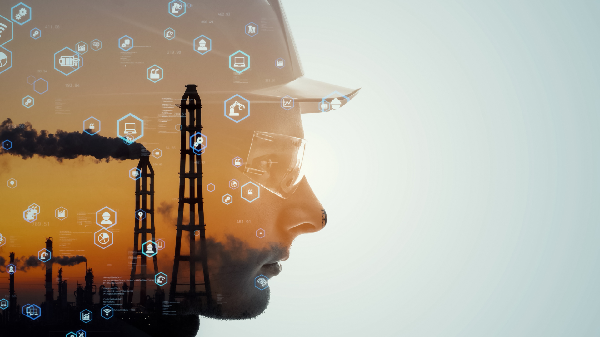 A double exposure of a man wearing a hard hat and glasses with an oil refinery in the background.