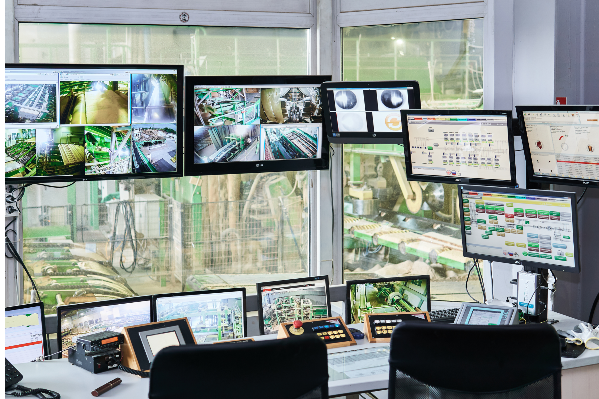 A control room with a lot of monitors and a window.