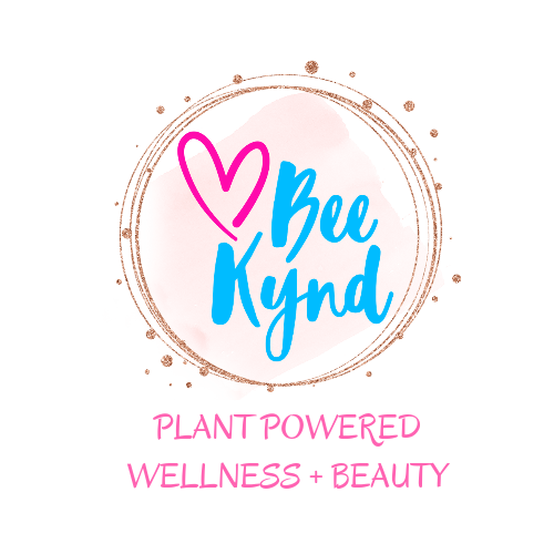 Logo for Bee Kynd, a plant-powered wellness and beauty brand, featuring a heart and text inside a gold circle.