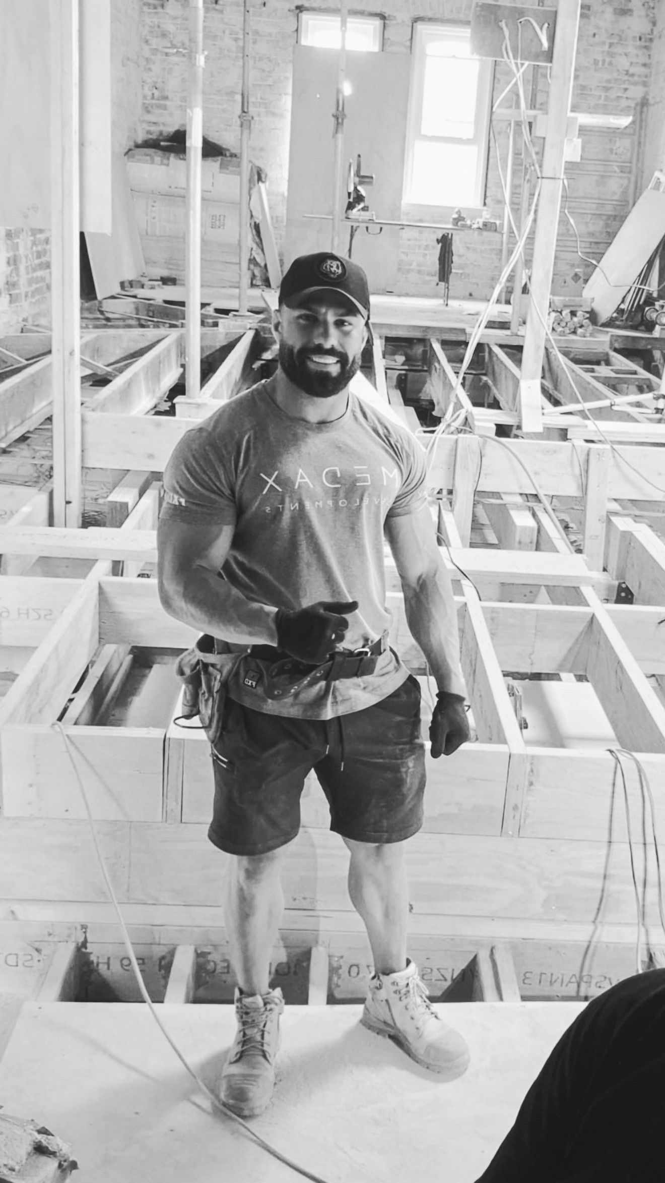 George is lifting dumbbells in a gym in a black and white photo.
