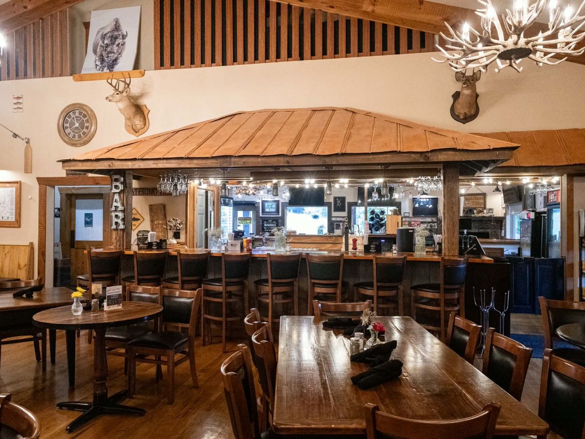 Rustic lodge bar area with antler chandelier