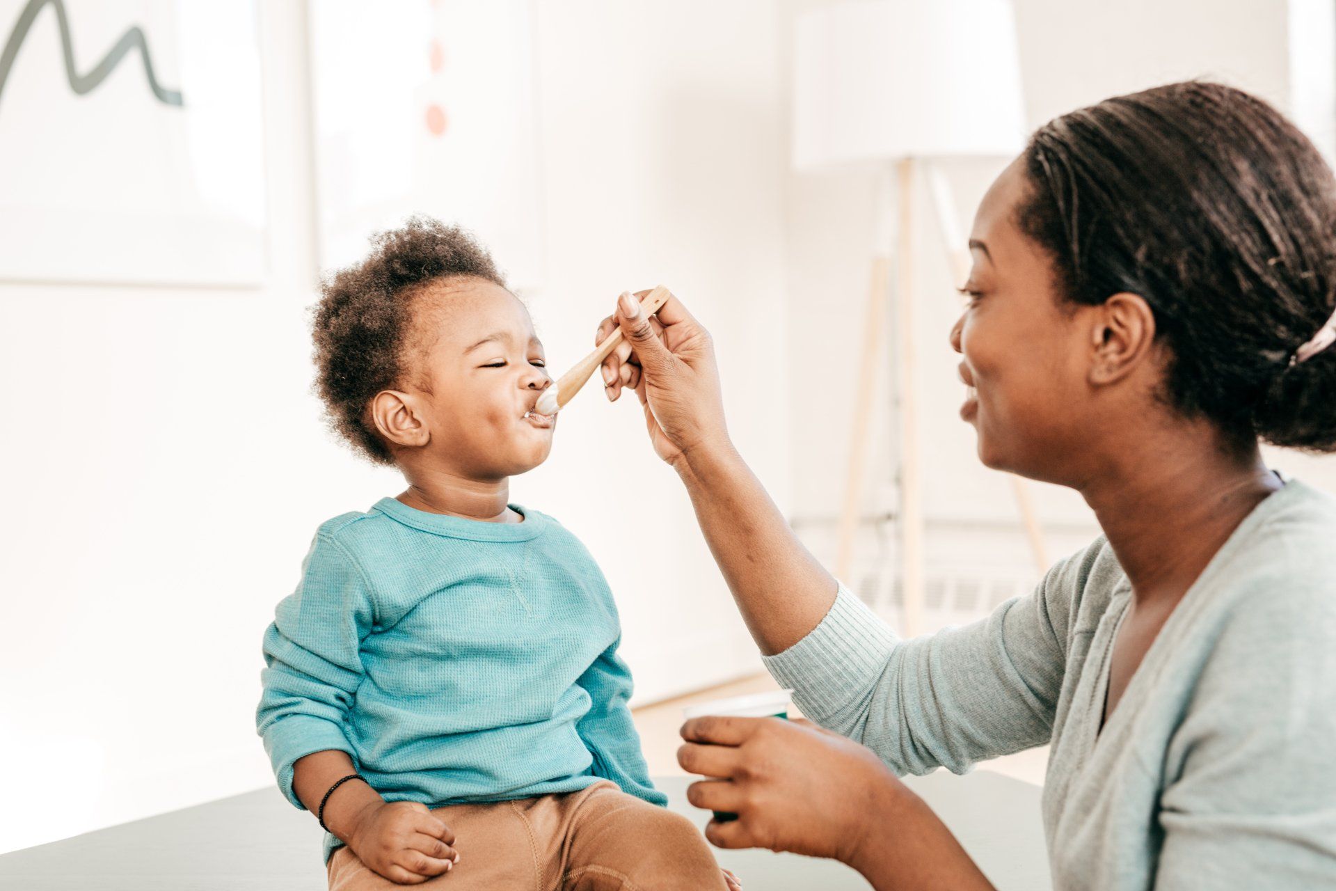 A woman is feeding a baby with a spoon.