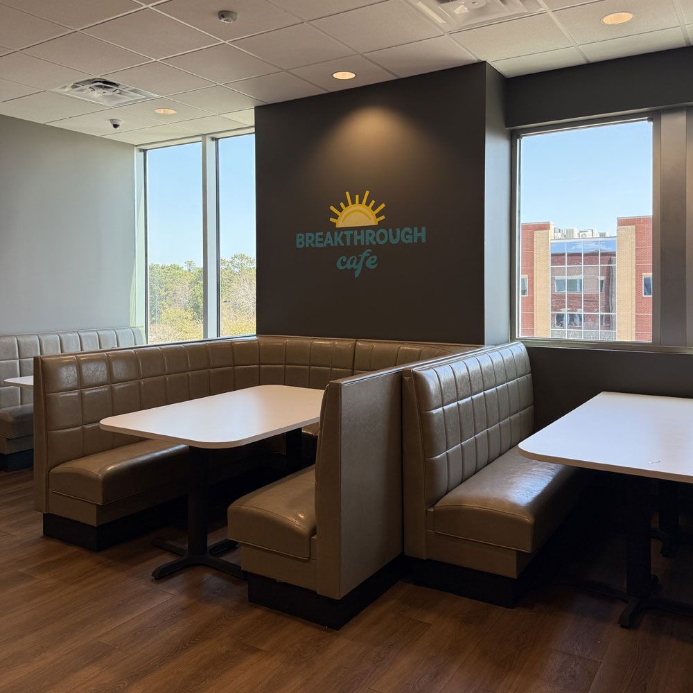 A restaurant with tables and booths called breakthrough cafe
