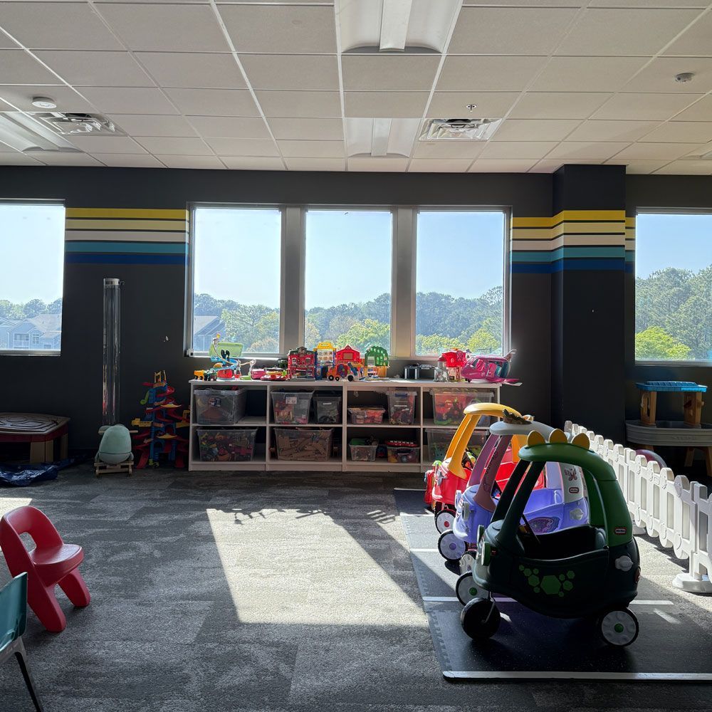 A room filled with lots of toys and a car on the floor.