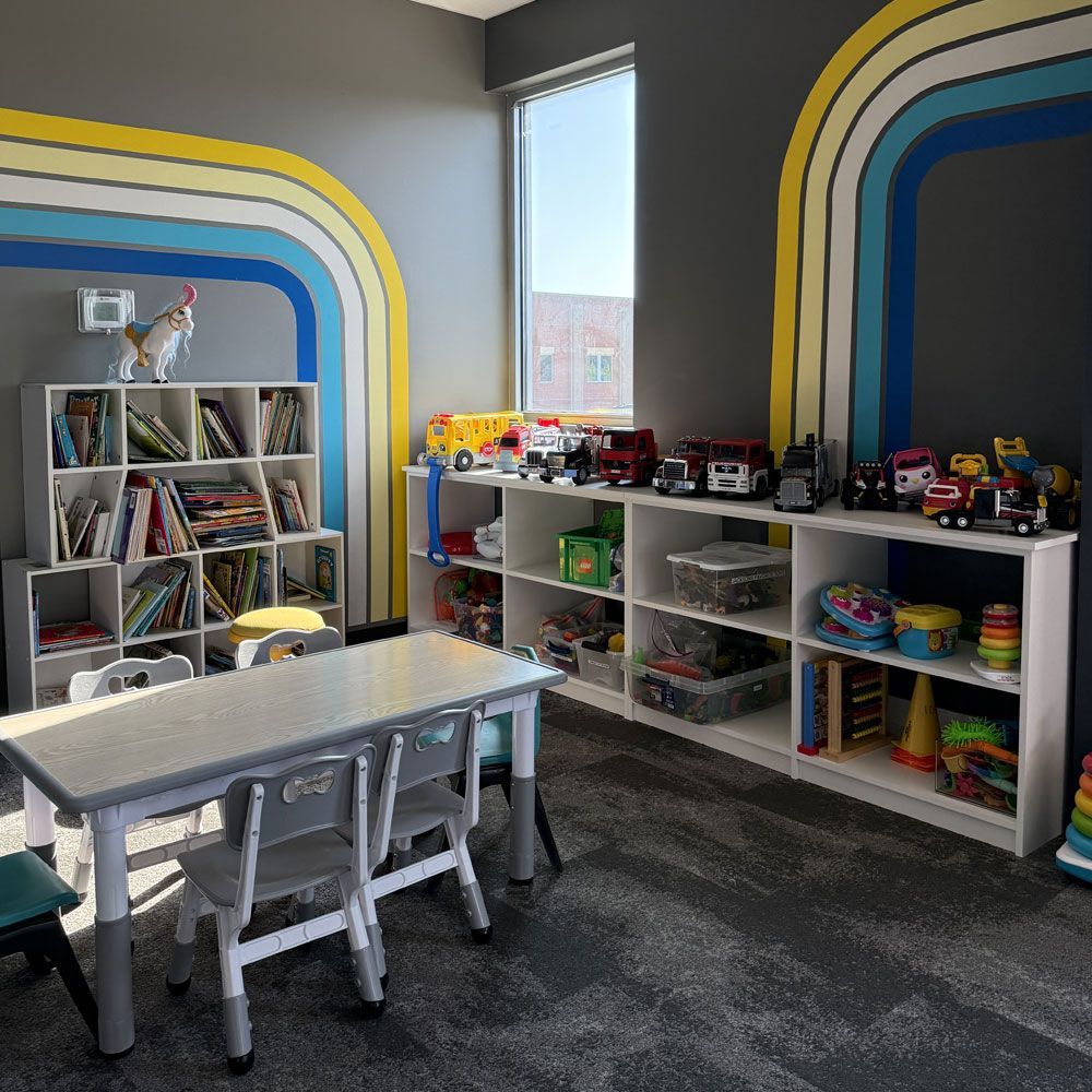 A room with a table and chairs filled with toys and books.