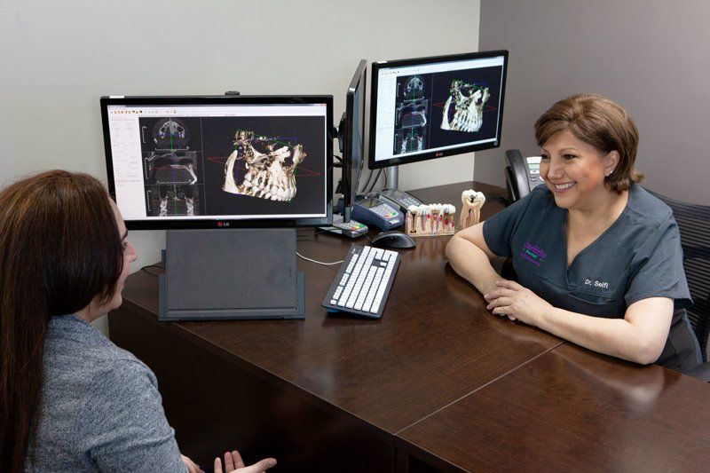 Dr. Maryam Seifi reviewing 3D dental scans with a patient at StarBrite Dental in Rockville, MD