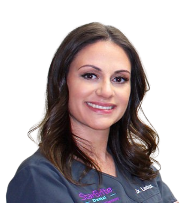 A woman in a scrub top is smiling for the camera.