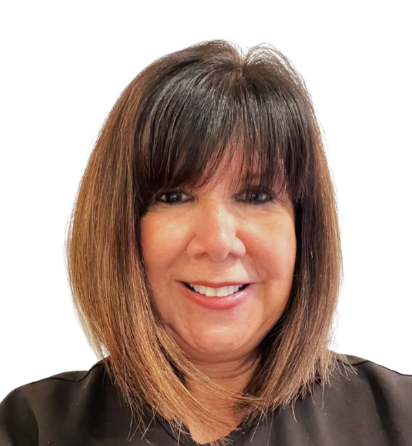 Woman with bob haircut and bangs, smiling.  Dark hair fades to brown at the ends. Wearing a dark top.