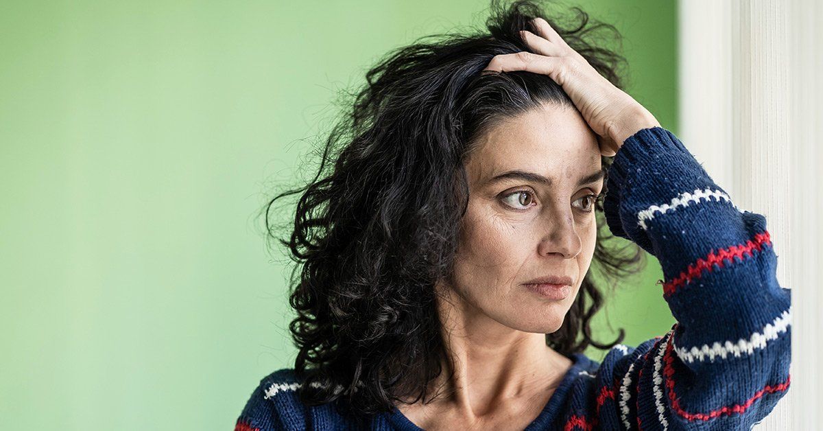 woman running fingers through hair and experiencing bruxism symptoms