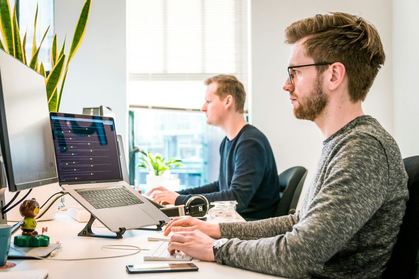 Laptop met moderne website en overleg tussen twee mensen – KeepUp Digital bouwt websites die werken