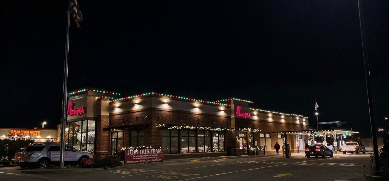 Nighttime view of a brightly lit restaurant building and parking lot