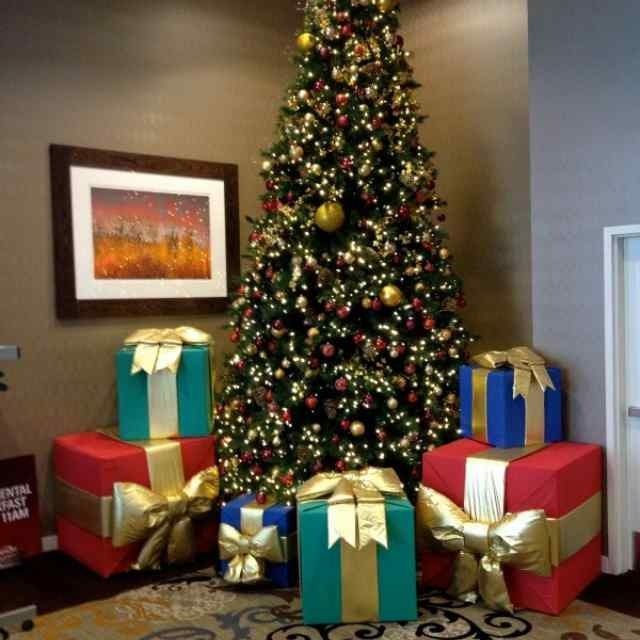 Decorated Christmas tree beside colorful wrapped gifts in a living room