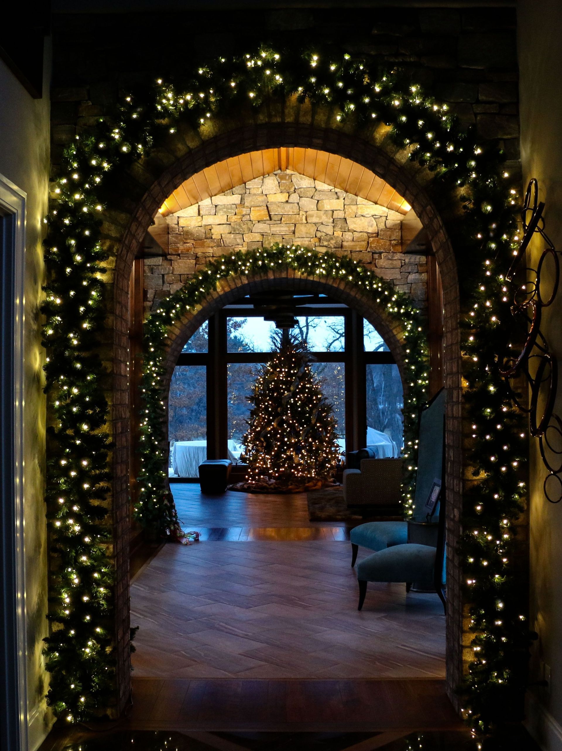 Festive archway with twinkling lights framing a holiday tree in a cozy interior room