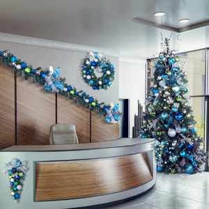 Decorated office reception desk with blue Christmas garland, wreath, and a lit blue-silver tree