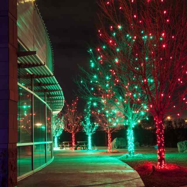 Building walkway lit by red and green holiday lights at night