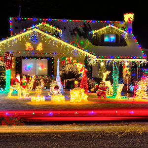 House covered in colorful Christmas lights and decorations at night
