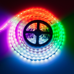 Colorful LED light strip coiled around a circular black symbol, glowing in rainbow hues on a dark background