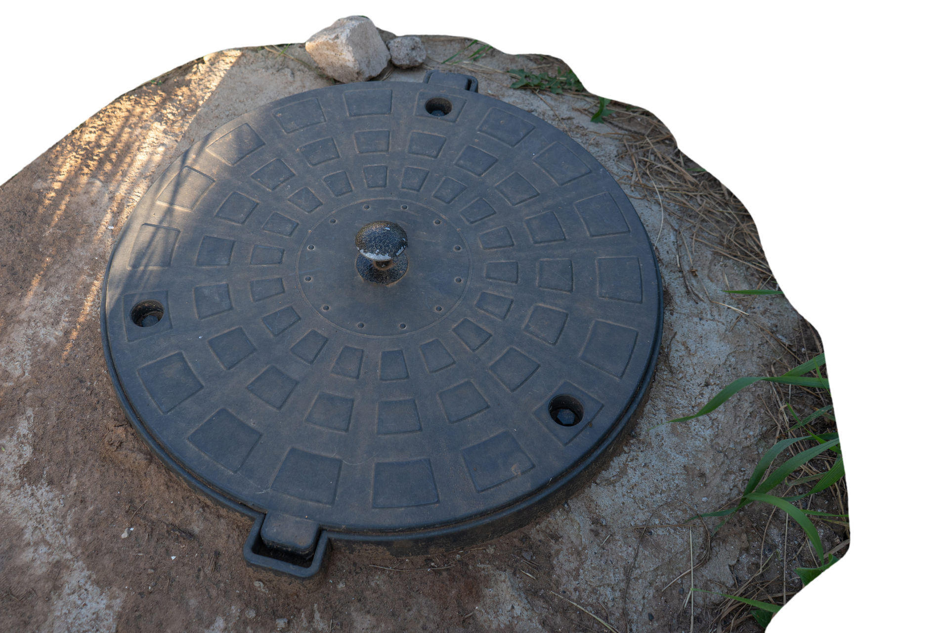 Black circular manhole cover set in concrete.