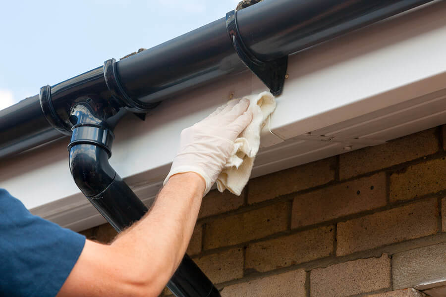 A person is cleaning a gutter with a cloth.