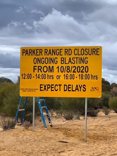 A yellow sign that says parker range rd closure ongoing blasting from 10/8/2020