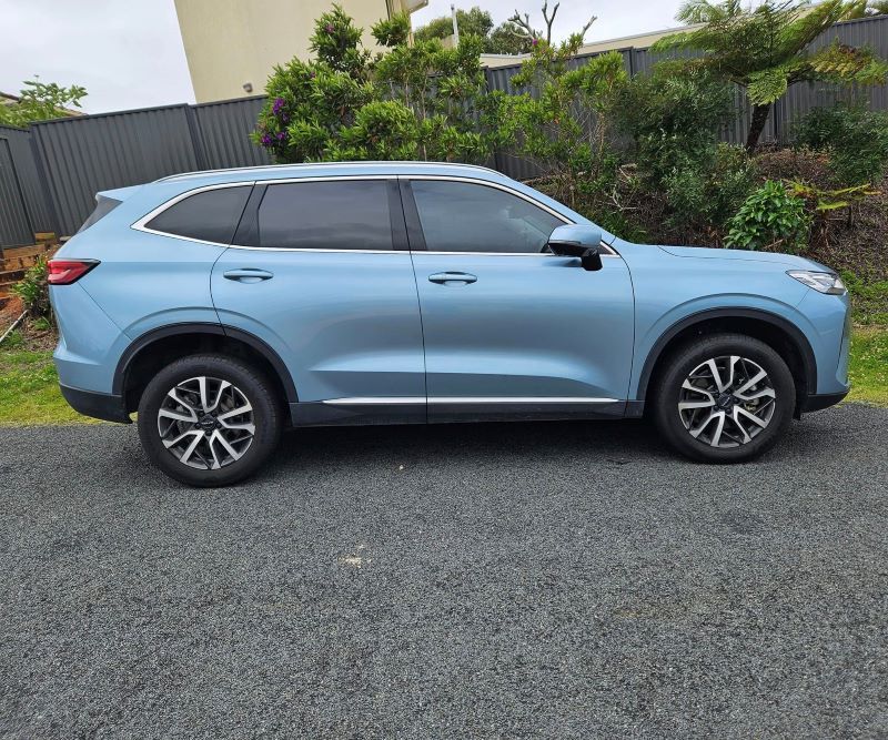A Blue Car is Parked on the Side of the Road Next to a Fence — PJ Tinting In Laurieton, NSW