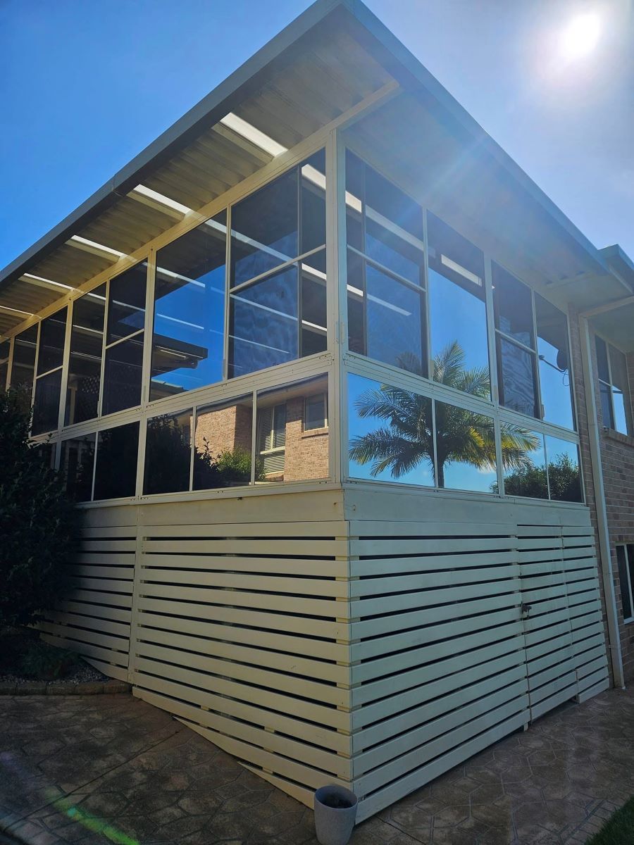 A Large House With a Lot of Windows and a White Fence — PJ Tinting In Port Macquarie, NSW