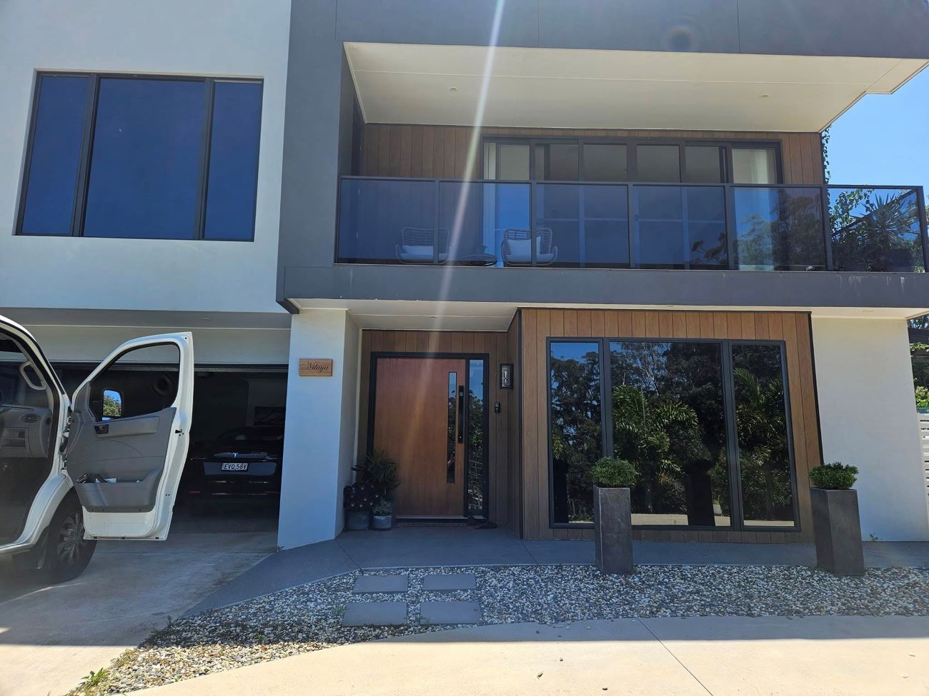 A Large House With a Car Parked in Front of It — PJ Tinting In Wauchope, NSW