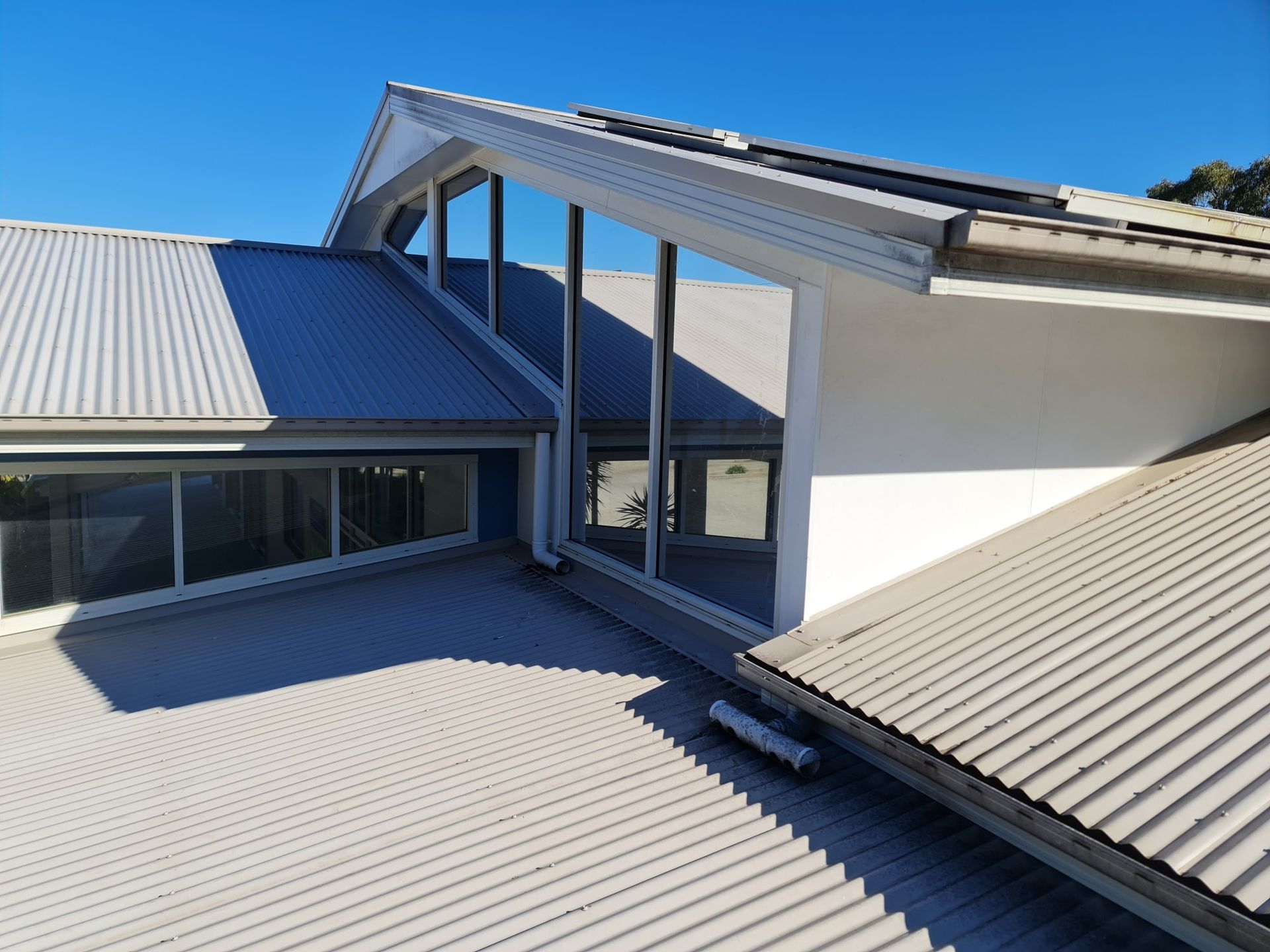 The roof of a house with a lot of windows and a blue sky in the background — PJ Tinting In Port Macquarie, NSW