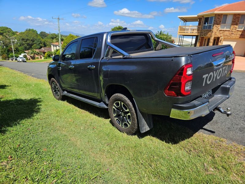 A Toyota Hilux Truck is Parked on the Side of the Road in Front of a House — PJ Tinting In Port Macquarie, NSW