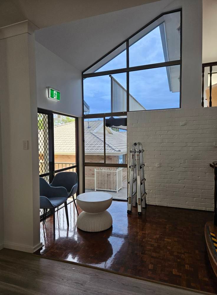A Living Room With a Table and Chairs and a Large Window — PJ Tinting In Port Macquarie, NSW