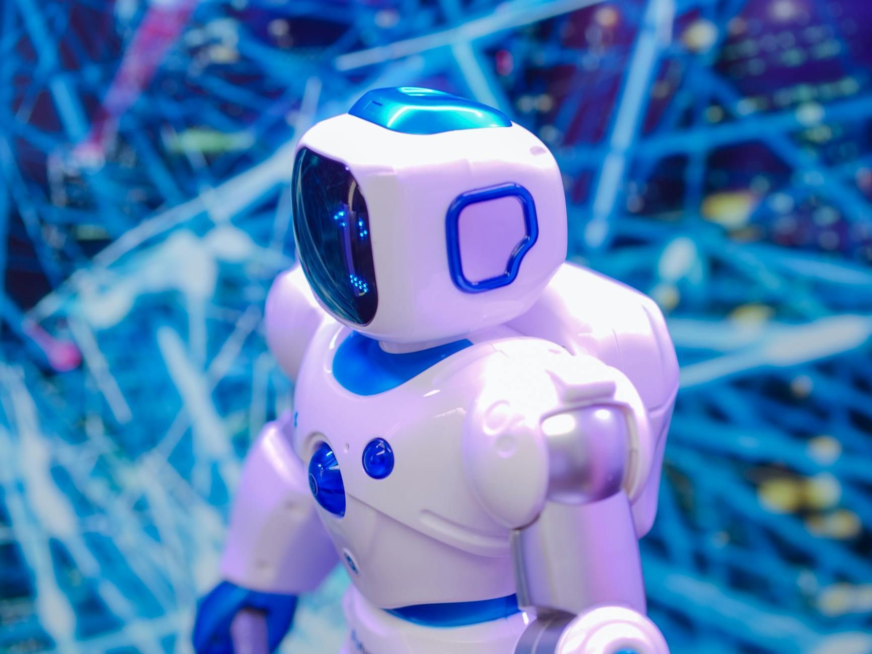 White and blue robot toy against a blue and white abstract background.