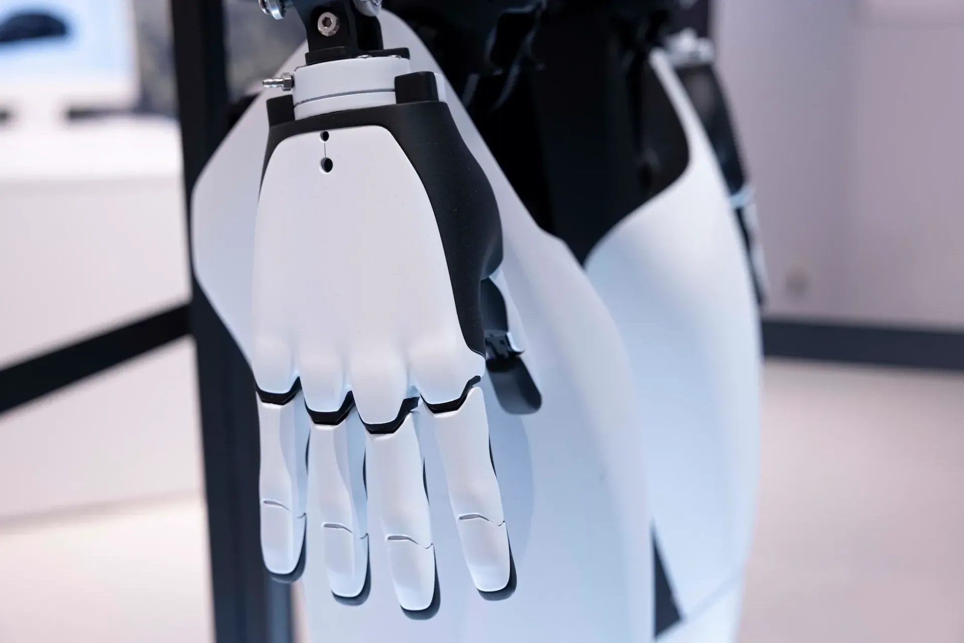 Robot hand, white and black, extended forward.