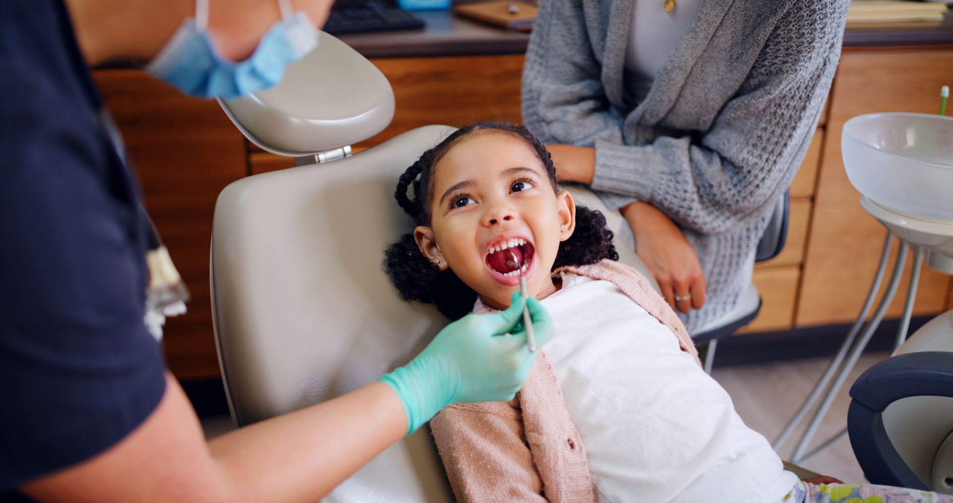 Pediatric dentist examining a child's teeth during an orthodontic consultation