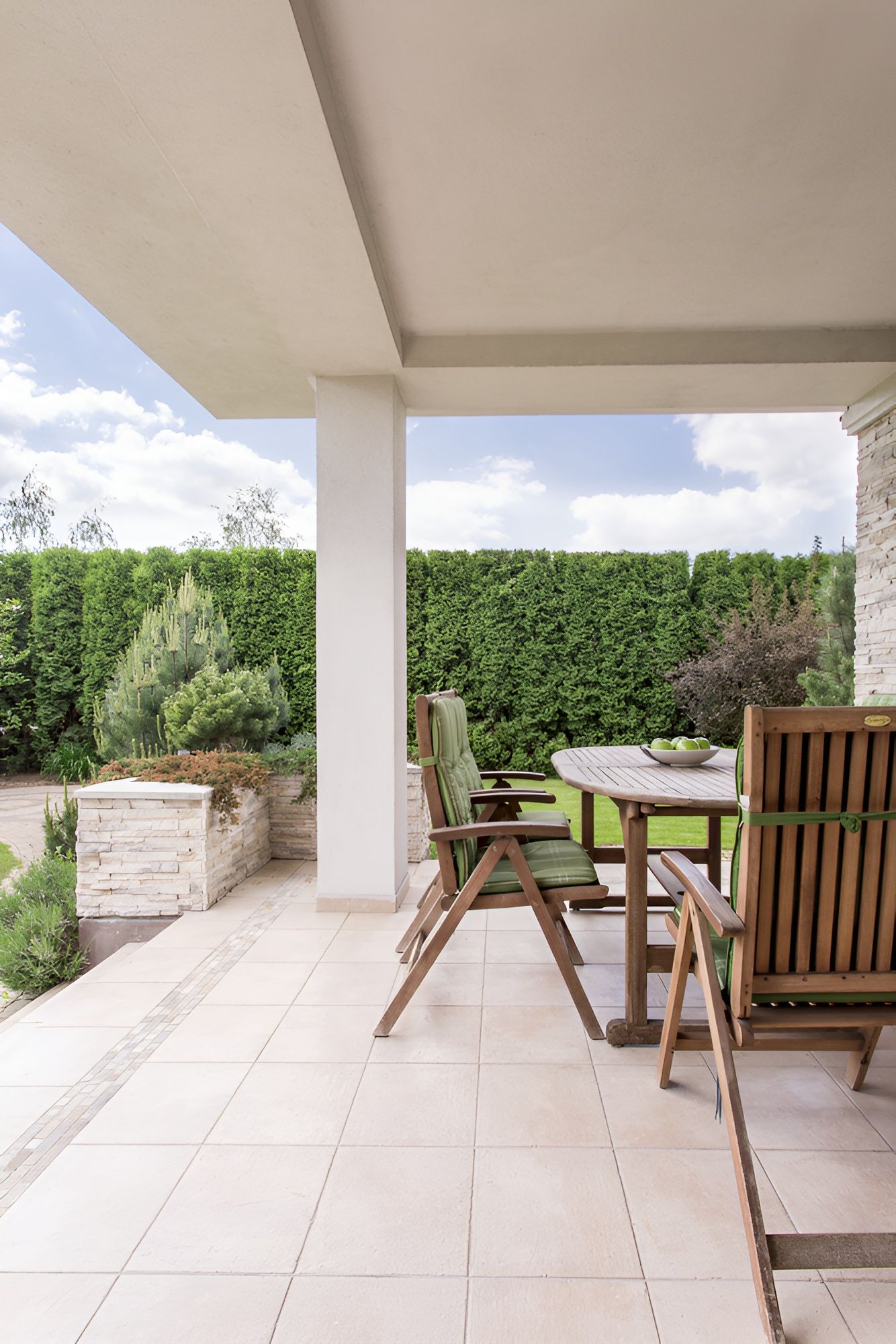 A Pergola With A Couch And Chairs Underneath It In A Backyard — Beckers Tiling in Bathurst, NSW