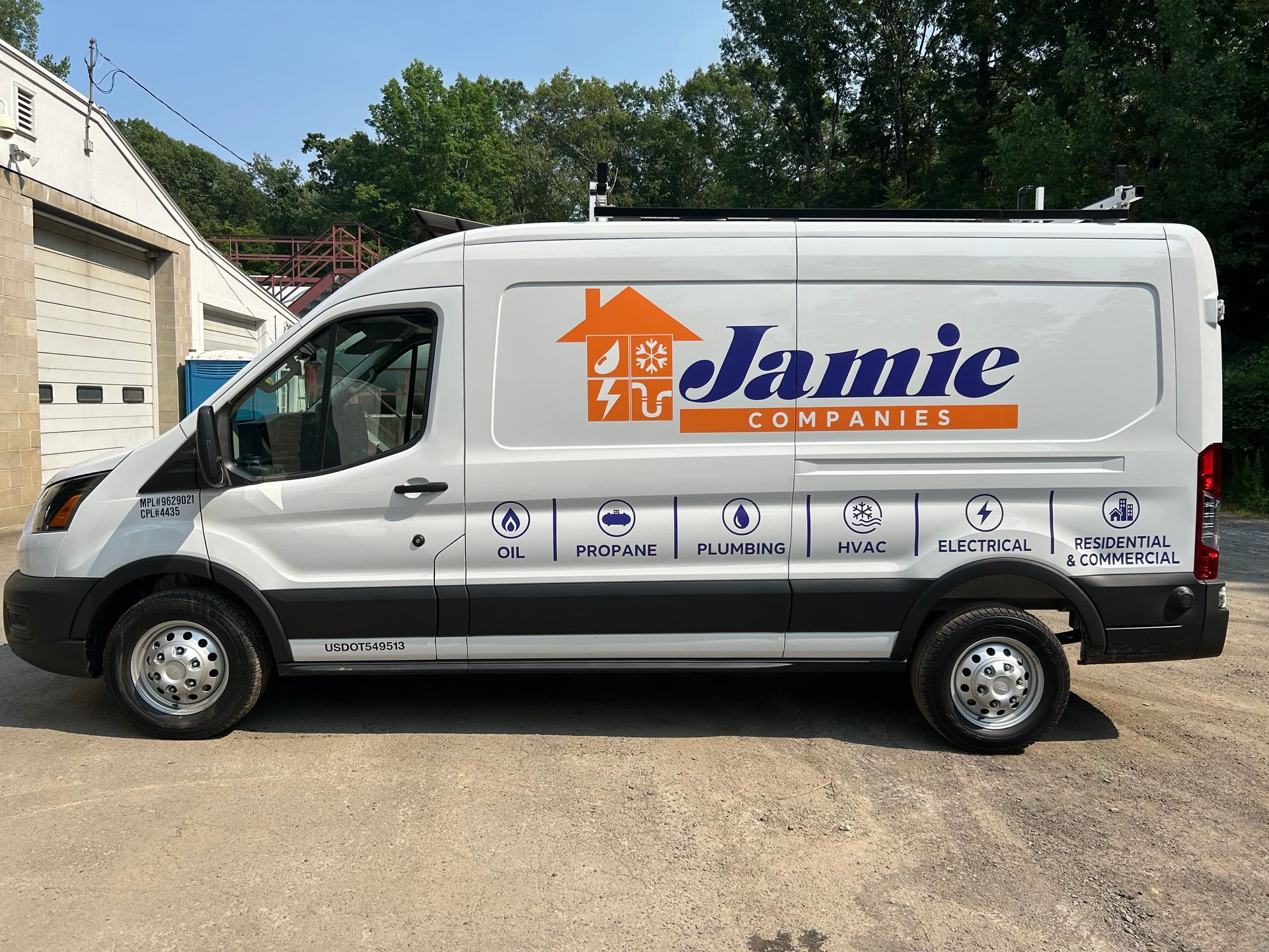 White Jamie Company cargo van parked outdoors beside a building.